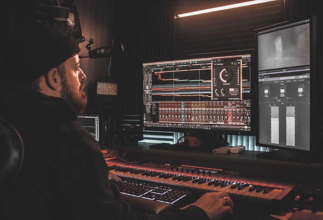 Broadcast engineer adjusting audio mixing console with waveform displays